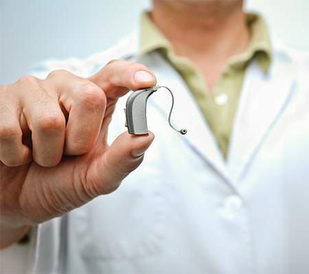 Hearing health professional holds over-the-counter hearing aids