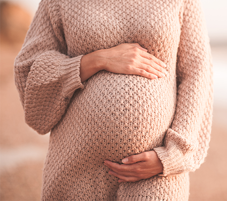 pregnant woman holds belly