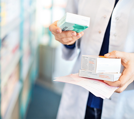 Pharmacist holding box of medications about to use mail-order pharmacy.