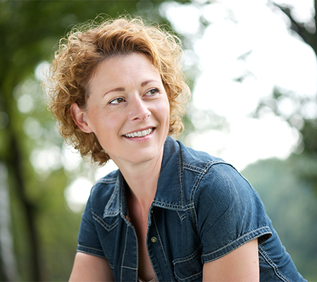 Woman outside thinking about detecting breast cancer with implants