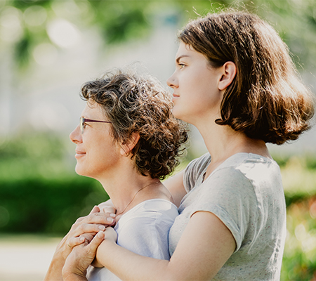Woman and daughter standing together talking about merkel cell carcinoma.