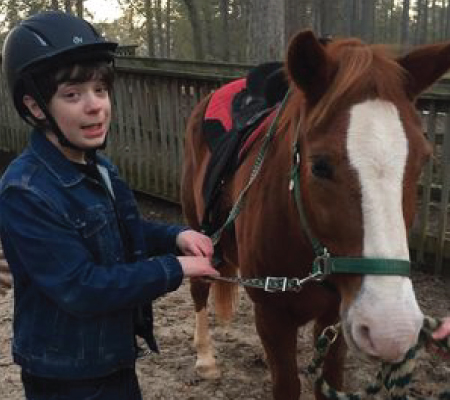 David McGlohon outside with horse living with Bardet-Biedl syndrome
