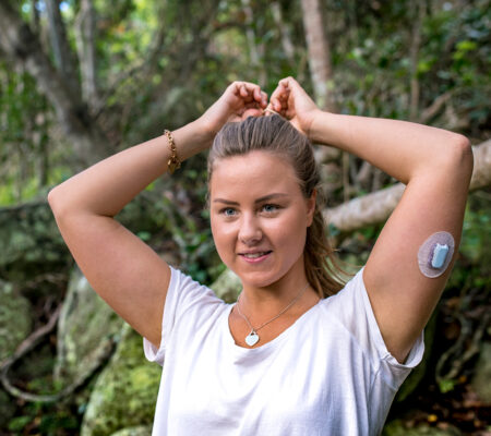 Weight loss surgery requirements: Woman with glucose monitor on her arm tightens her pony tail, like she's getting ready to exercise