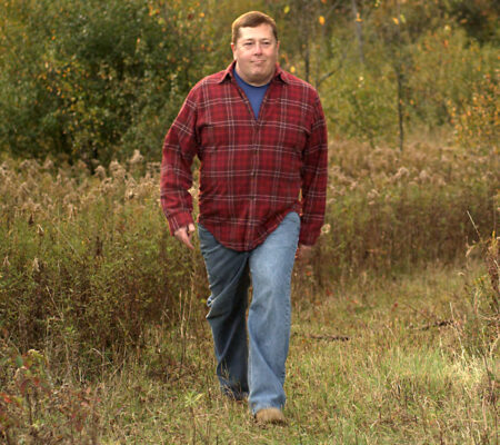 man walking in field for exercise before hunting season
